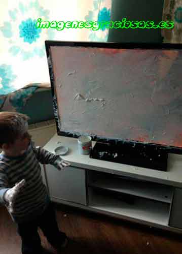 foto graciosa con niño pintando la television